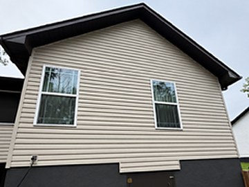 The same gable end after soft washing, the siding back to clean tan