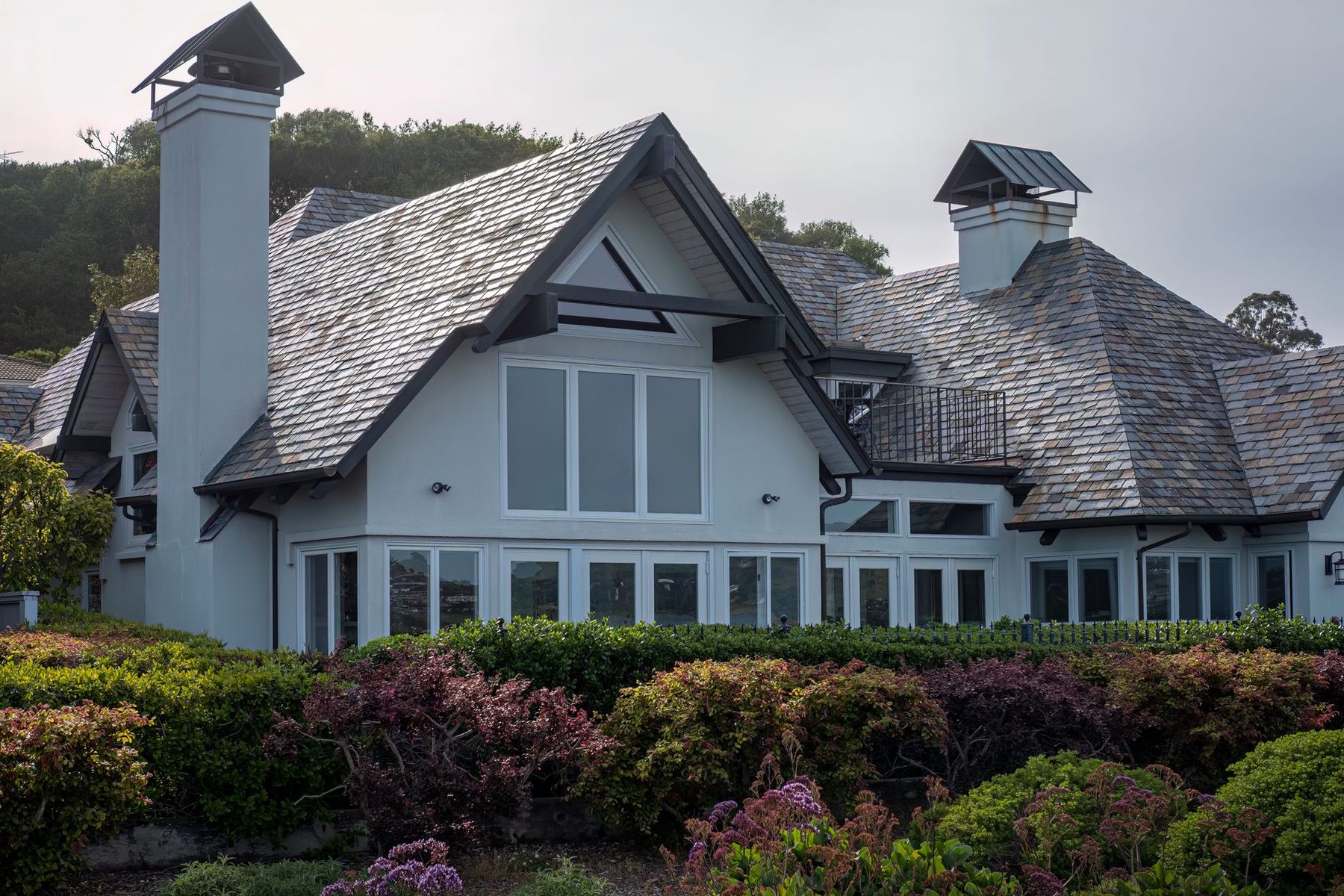 A shingle roof on a large home, clear of algae streaks