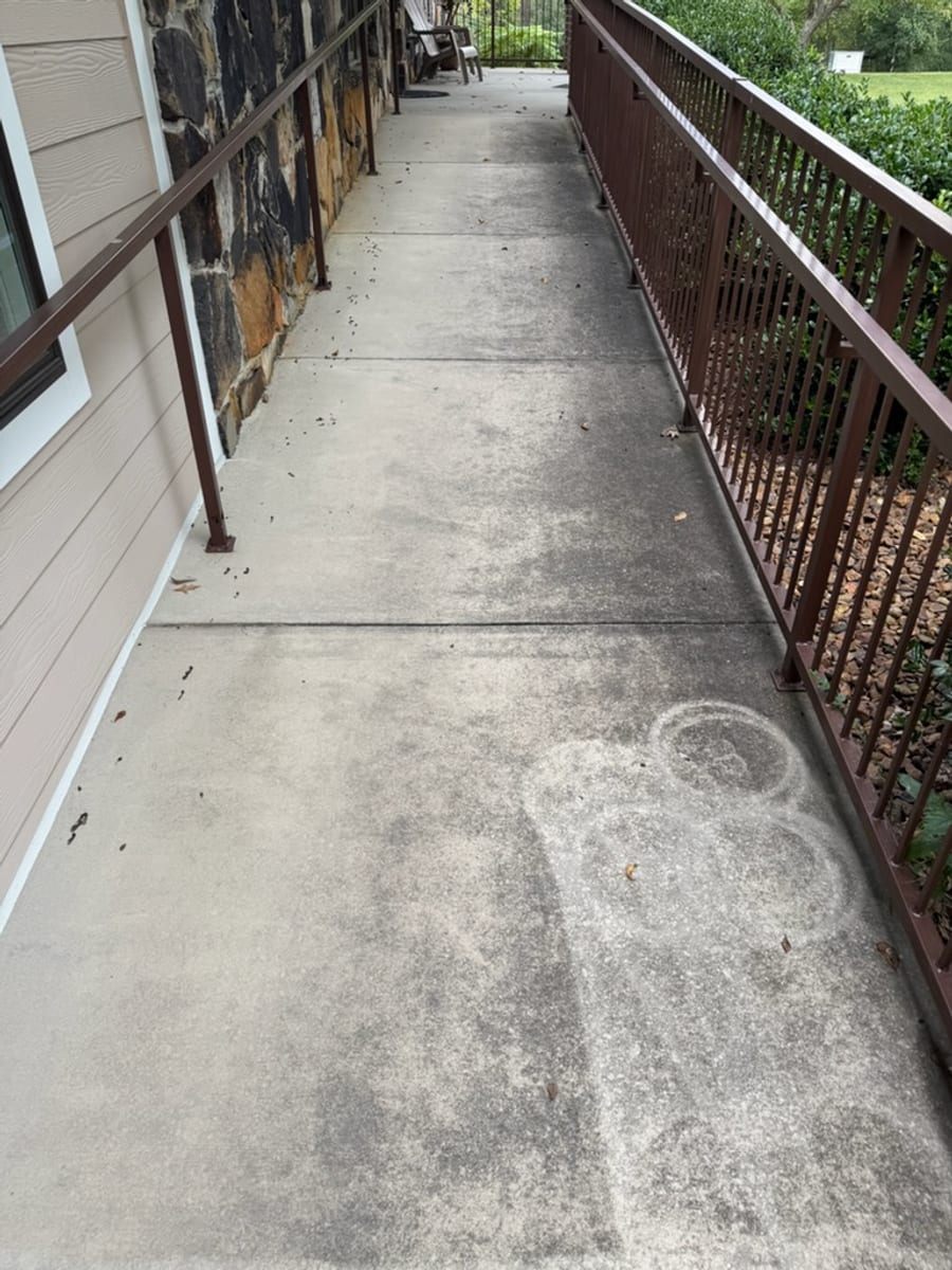 Covered concrete walkway before washing, greyed with algae and pale rings where planters had stood