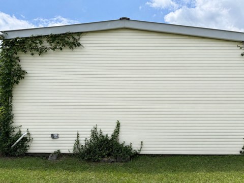The same wall after soft washing, clean cream panels end to end